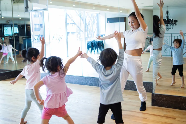 教室で子どもたちと講師がダンスをしている様子
