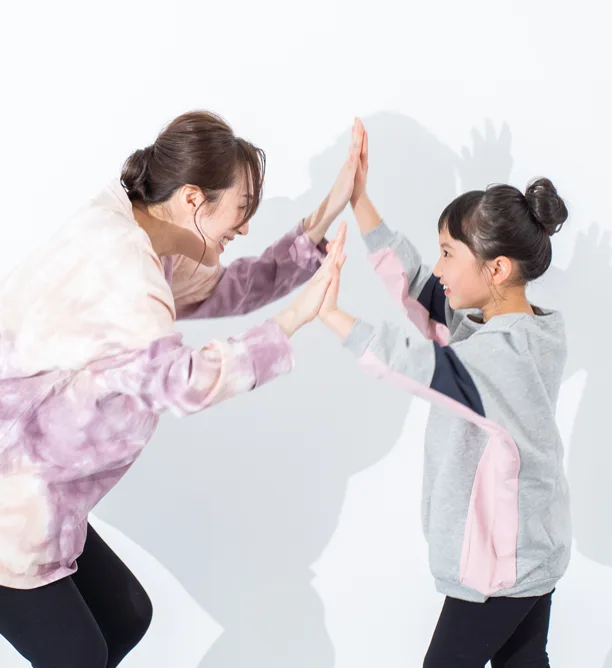 講師と子どもがハイタッチをしている様子